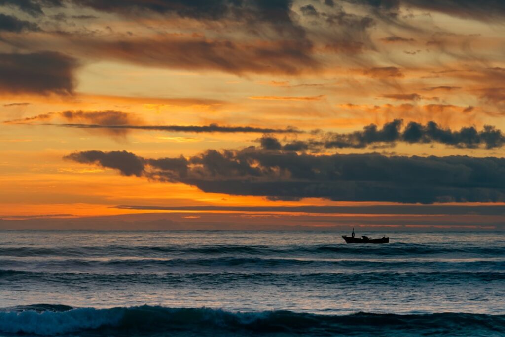 Piccolo pescatore su una banchina, silhouette al tramonto