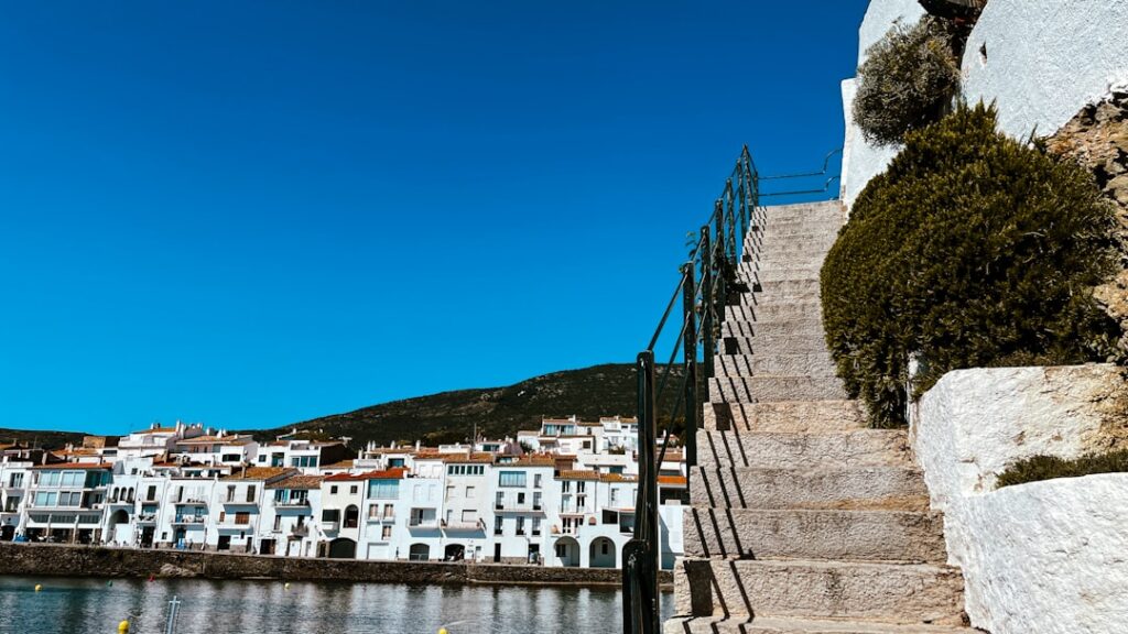 Stone steps rising beside seaside white houses under clear blue sky