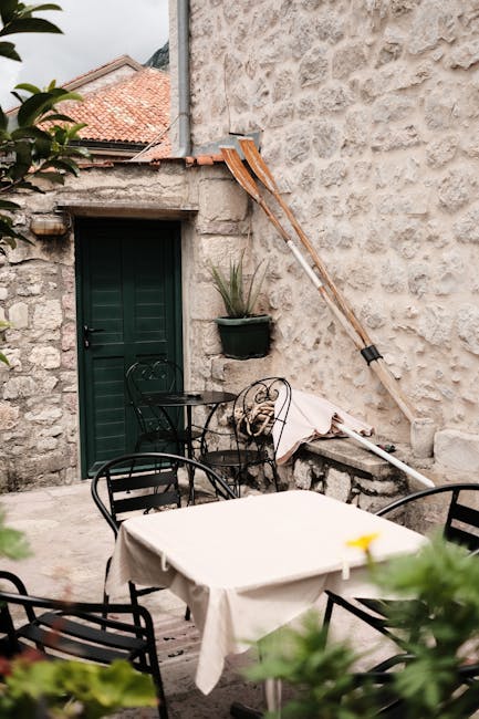 Cortile tranquillo a Kotor con tavolo, sedie e remi appoggiati
