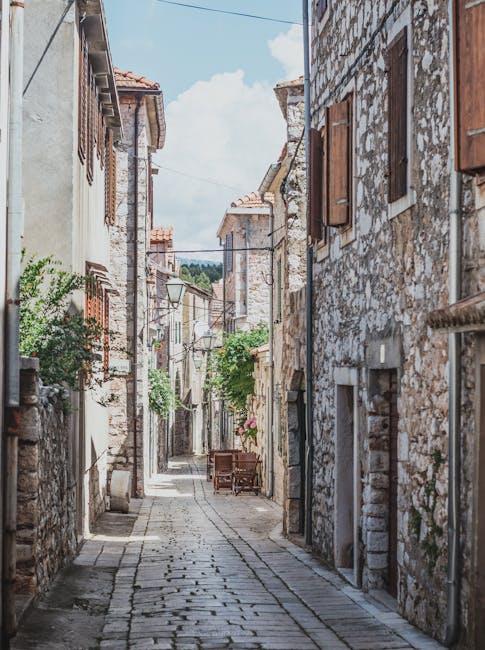 Quiet stone alley in Kotor lined with shuttered buildings