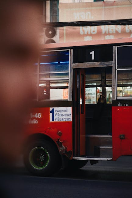 Roter Linienbus mit offener Tür und Nummer 1 an der Haltestelle