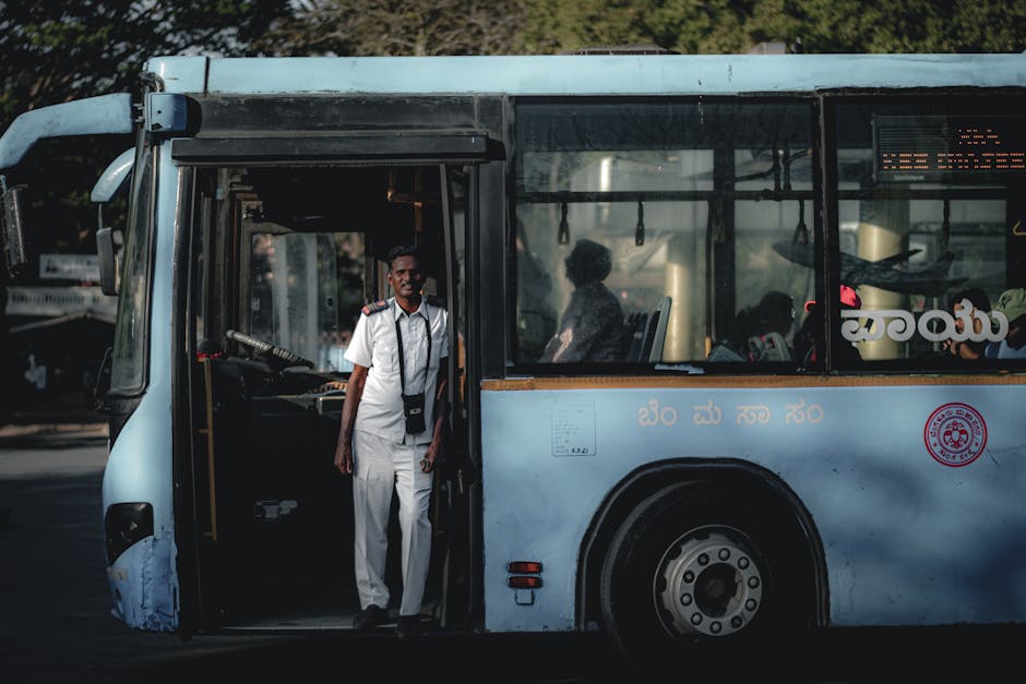 Autista in uniforme alla porta di un autobus urbano in città