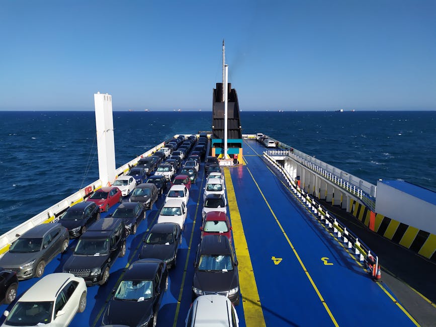 Car ferry deck loaded with rows of vehicles crossing open sea.