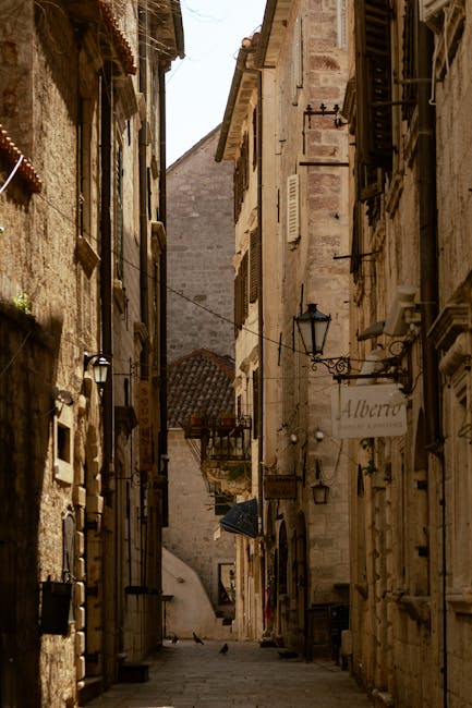 Rustige smalle steeg in Kotor met lantaarns en twee duiven