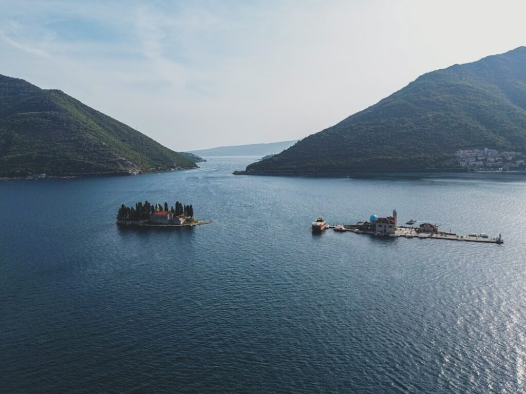Zwei kleine Inseln in der Bucht von Kotor zwischen grünen Bergen