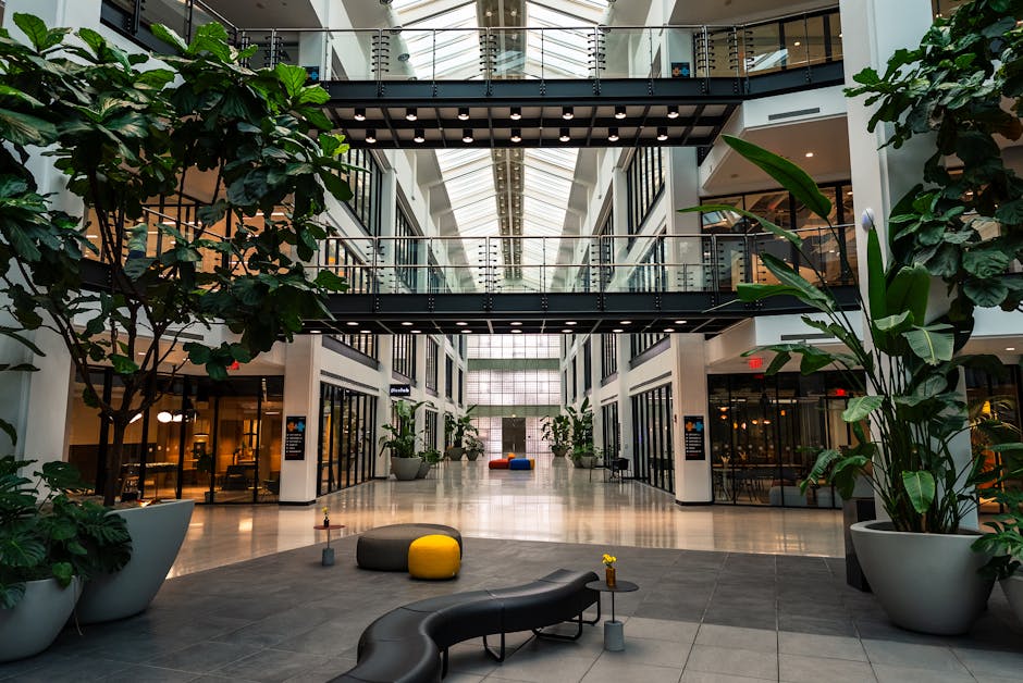 Spacious atrium with benches, plants, and skylight in modern building