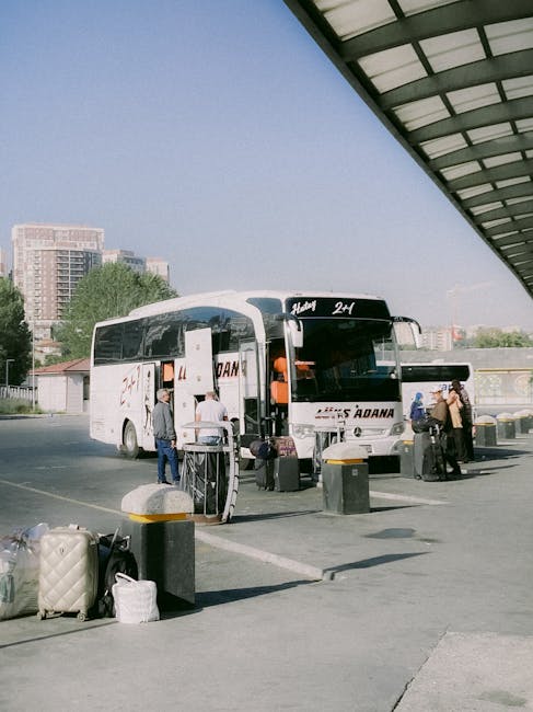Reisebus an Busterminal, Reisende laden Koffer und Gepäckstücke ein