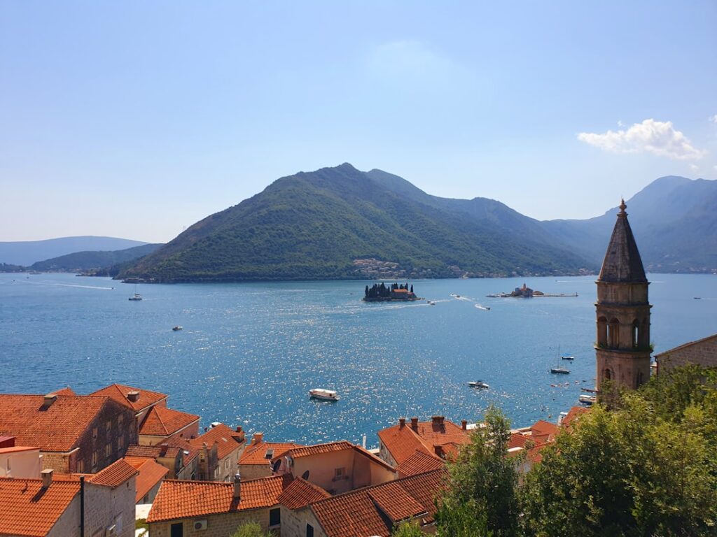 Bucht mit roten Dächern, Inseln und Kirchturm bei Kotor