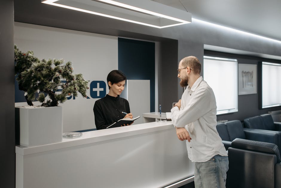 Empfangstheke in Klinik mit Mitarbeiterin, die Patientendaten notiert