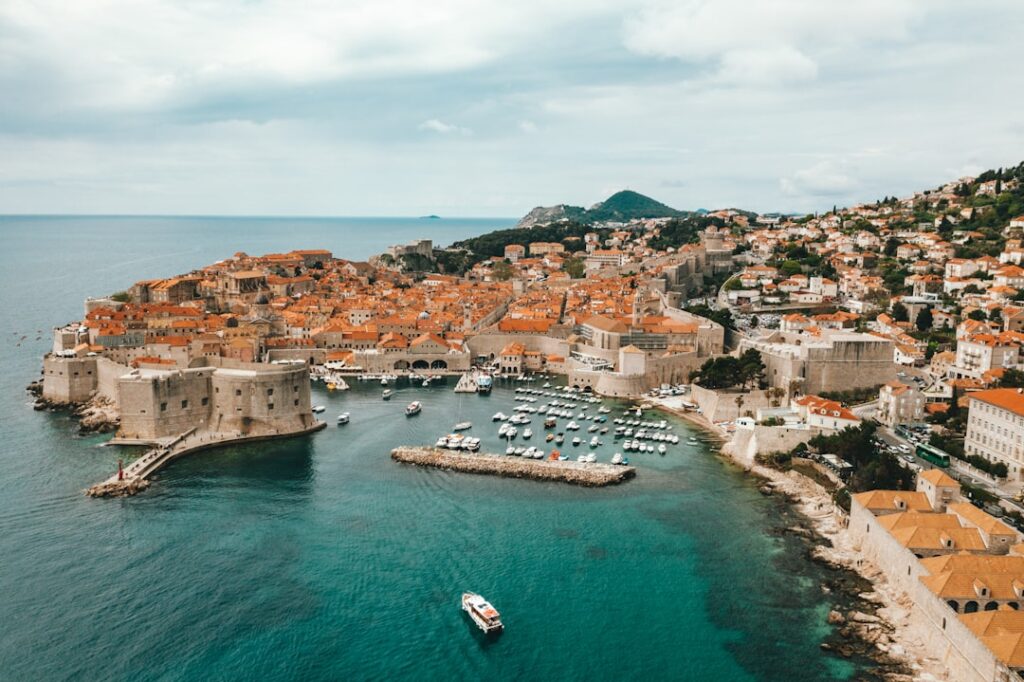 Aerial view of Dubrovnik's walled old town and harbor with boats