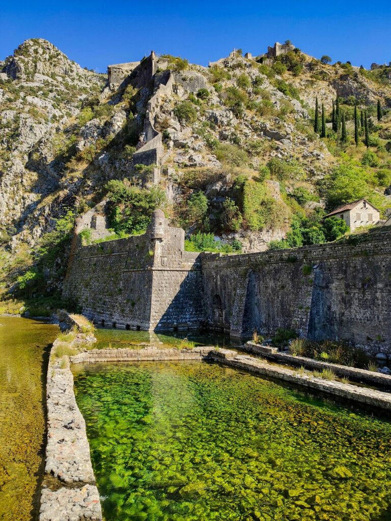 Traghetto che si avvicina alla costa di Kotor con la città vecchia visibile