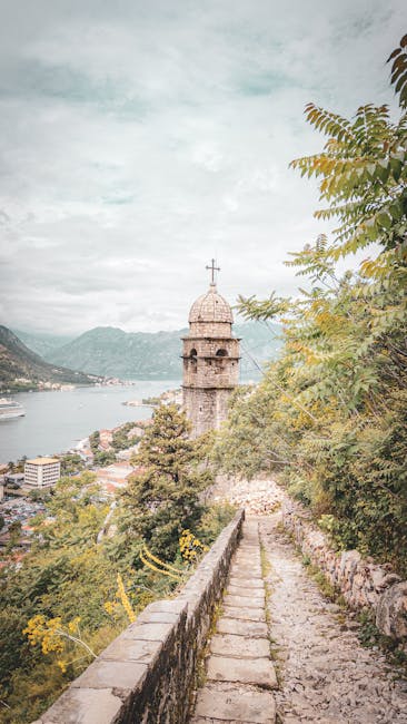 Stone walkway leading to a bell tower overlooking Kotor Bay and cruise ships