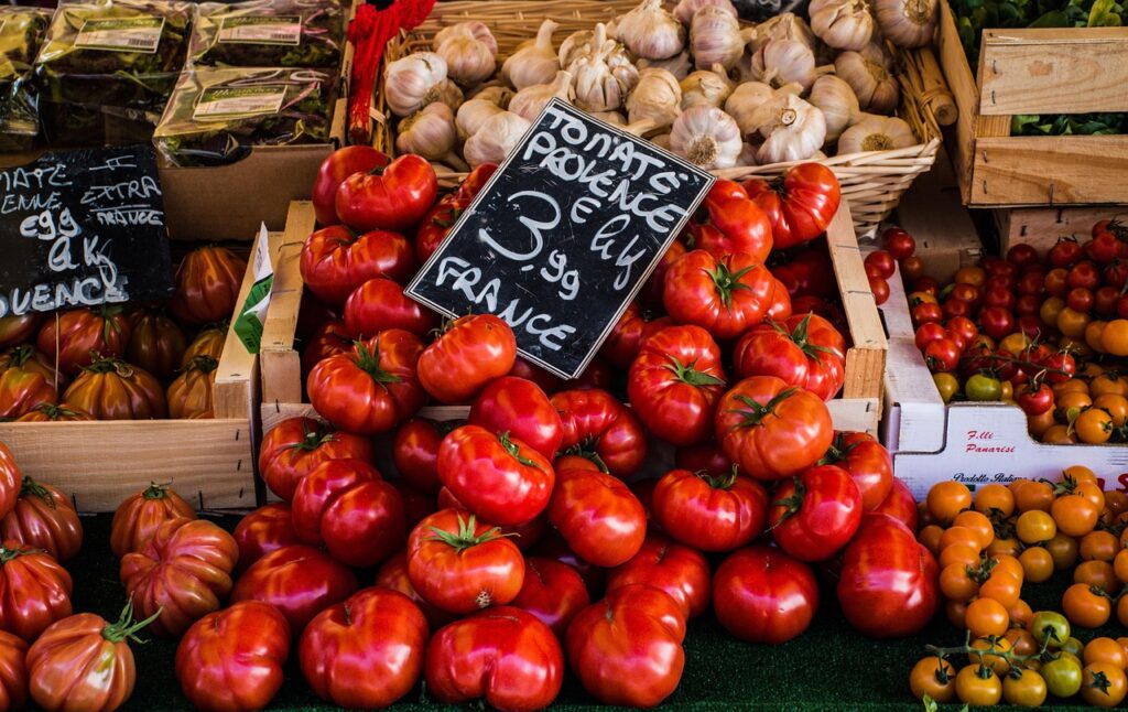 Cassette piene di pomodori rossi e spicchi d'aglio al mercato