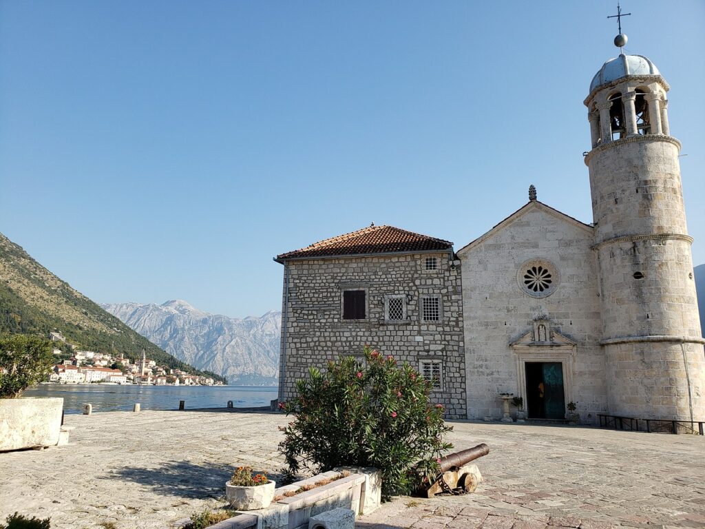 Historische kerk aan waterkant met uitzicht op Kotor-baai en bergen