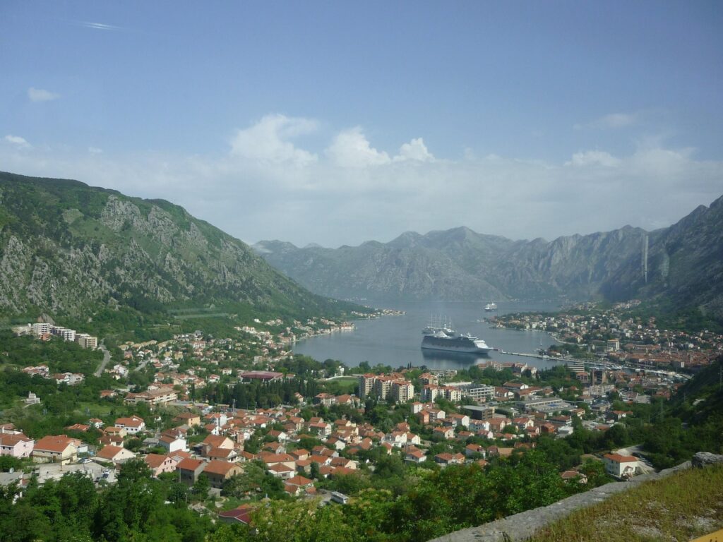 Panoramic view of Kotor Bay with cruise ship docked and red-roof town