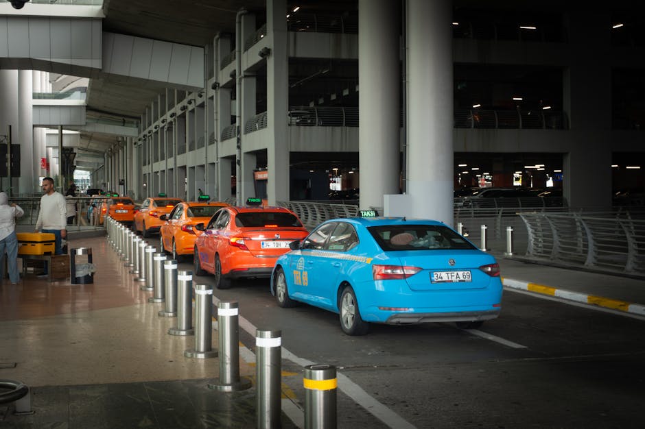 Row of blue and orange taxis queued at airport curb bound for Kotor