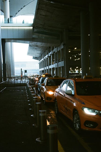 Nighttime line of orange taxis under covered airport canopy for Kotor travelers
