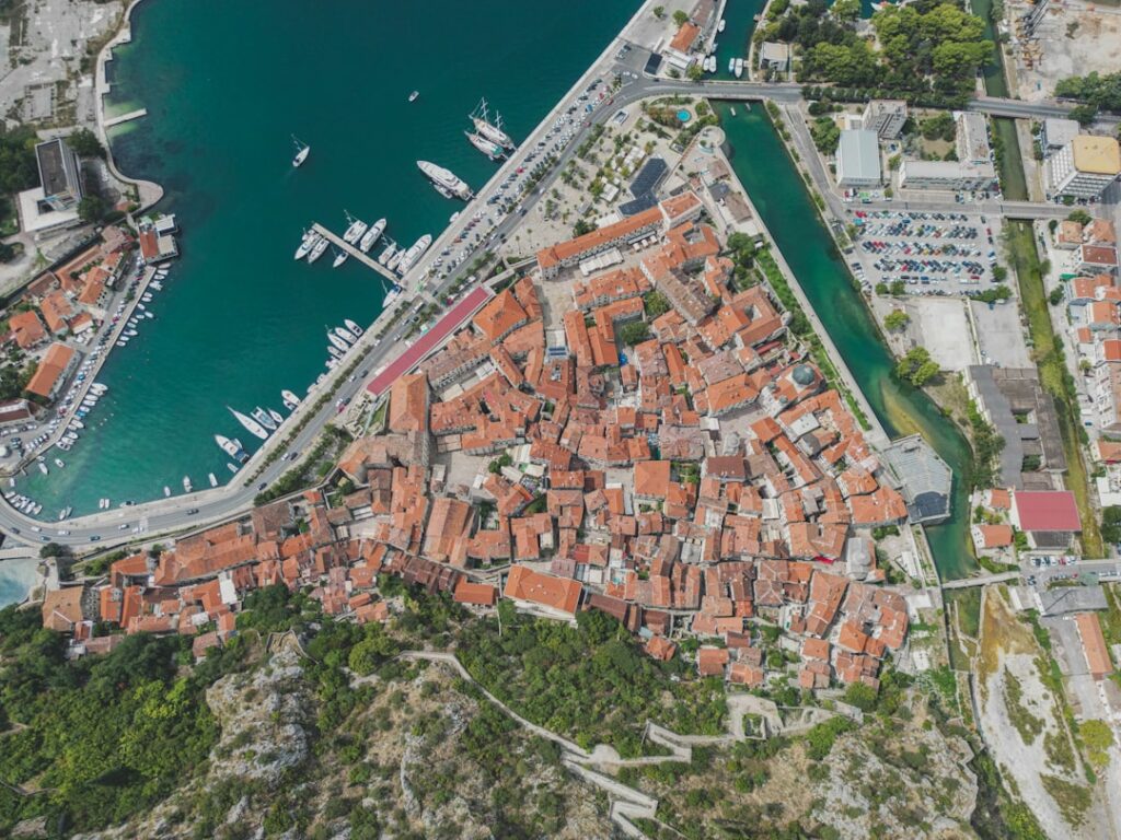 Aerial view of Kotor old town's red roofs, ancient walls and marina