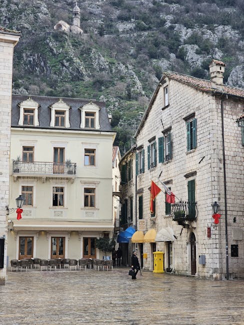 Historic Kotor square showing stone buildings, wet pavement and few pedestrians
