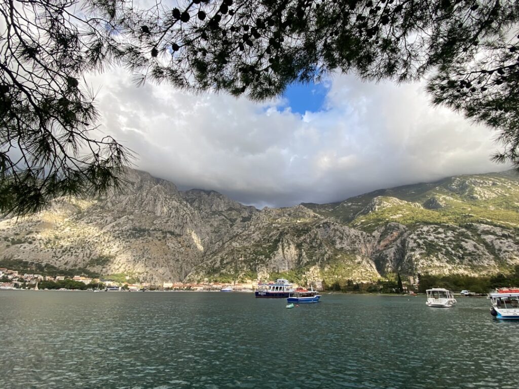Uitzicht over de baai van Kotor met boten en steile bergen