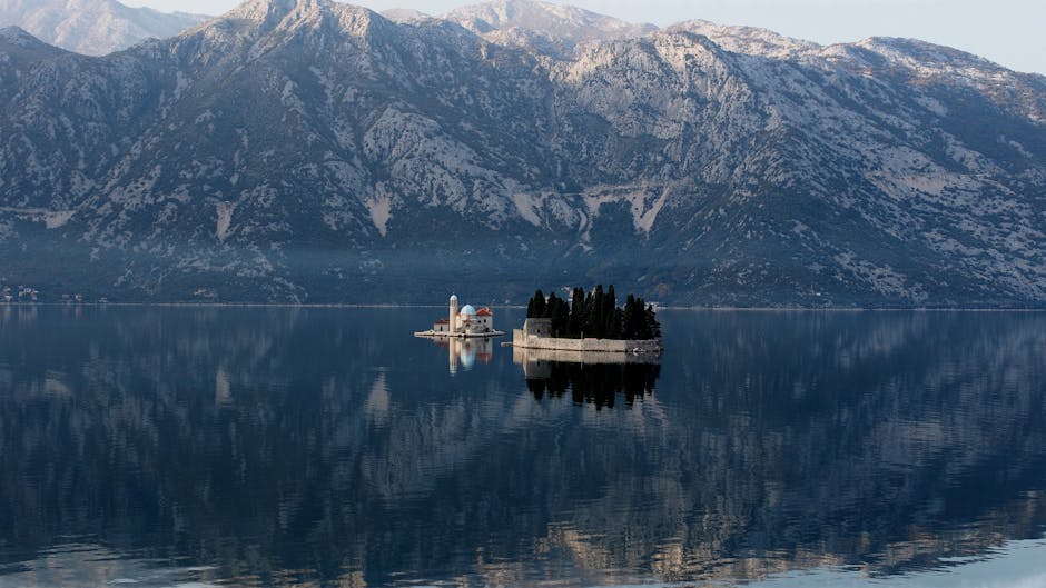 Kerkje op kunstmatig eiland in Baai van Kotor met bergreflectie