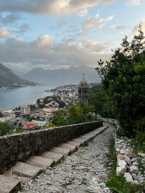 Steinerne Treppe hinab mit Blick auf Kotor-Bucht und Kirchturm.