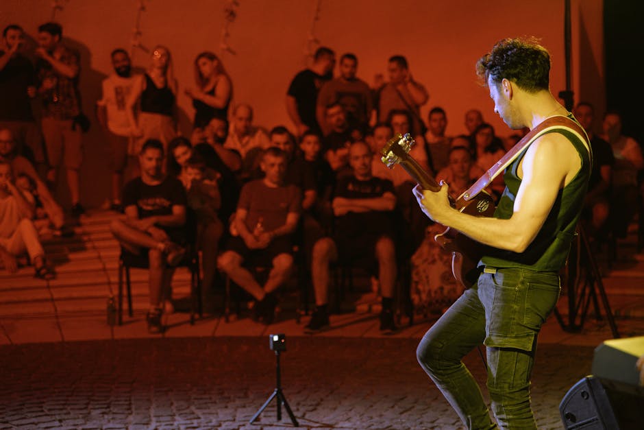 Gitarist speelt voor publiek op plein tijdens avondconcert in Kotor