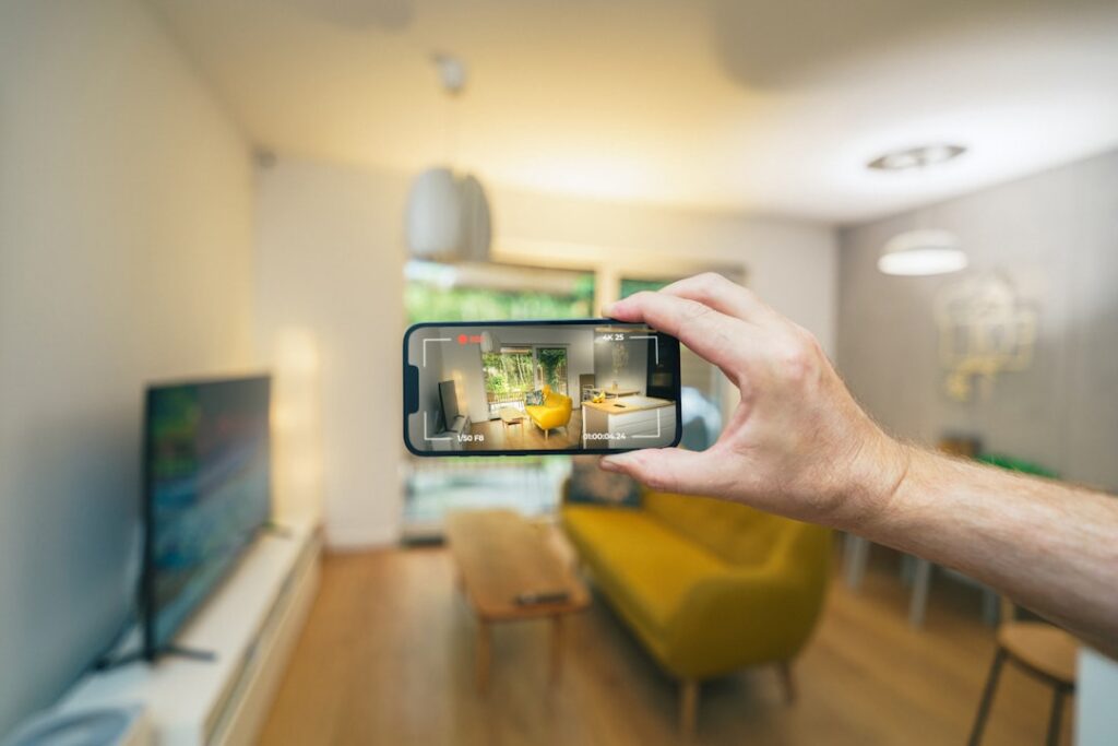 Person filming apartment interior on smartphone to showcase Tirana rental