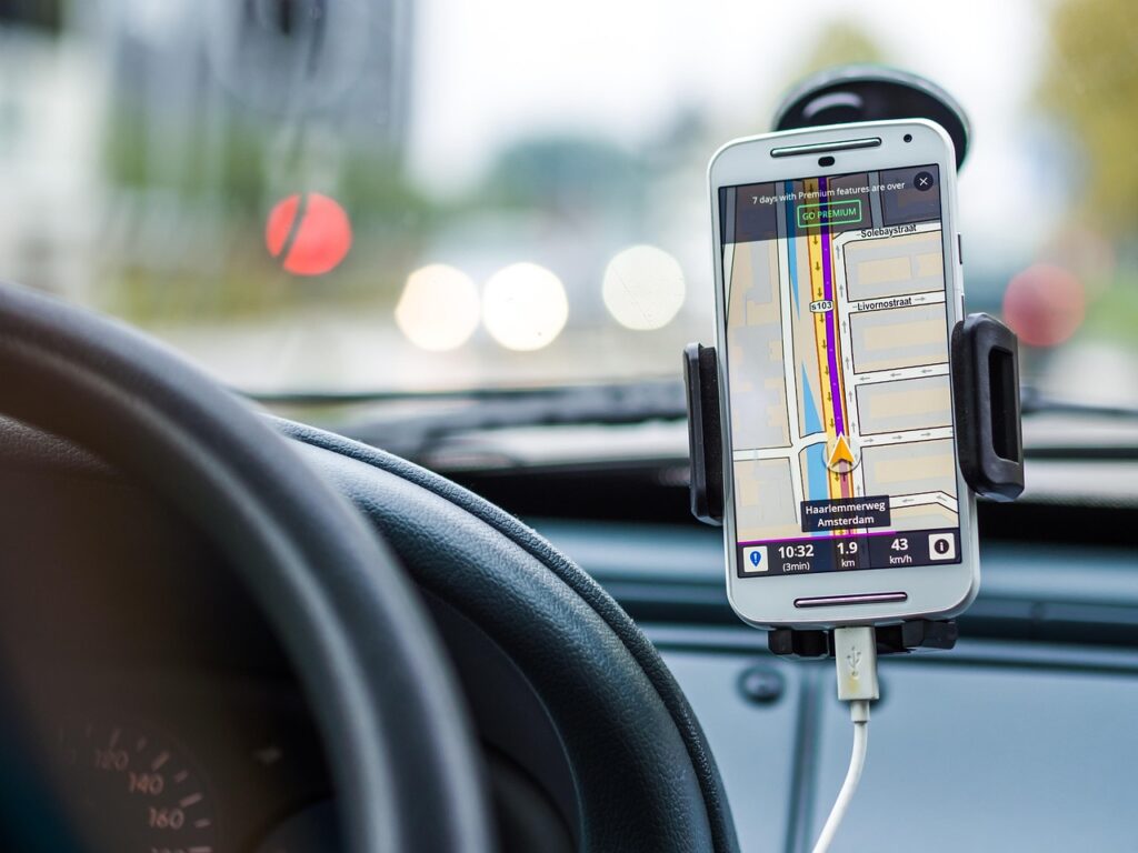 Smartphone fixé sur le tableau de bord affichant un itinéraire GPS