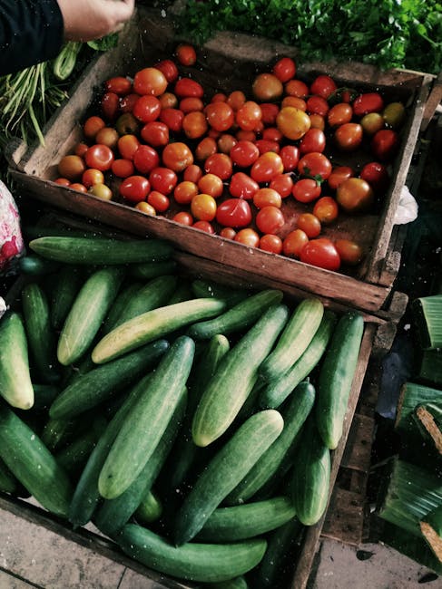 Wooden crates of ripe tomatoes and cucumbers at Tirana stall