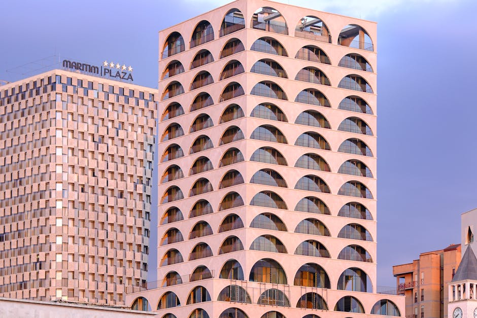 Arched concrete residential building and Maritim Plaza hotel in Tirana skyline