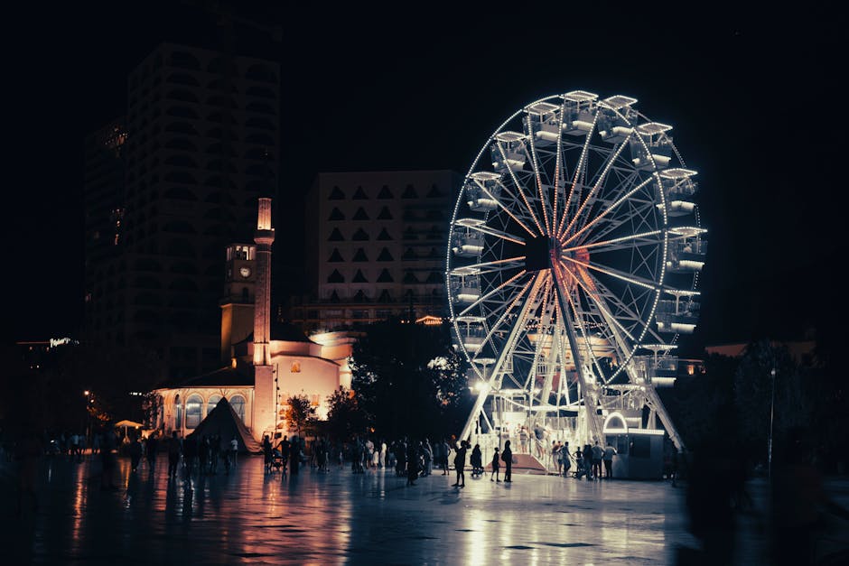 Illuminated Ferris wheel and crowd in Tirana square at night