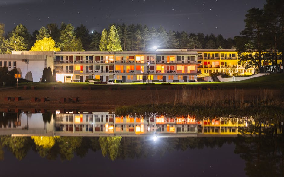 Hotel building by water reflecting at night near Tirana