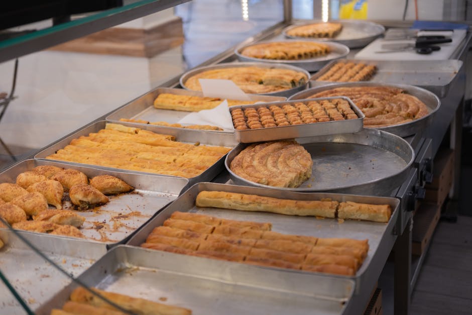Rows of baked savory pastries displayed on trays in Tirana bakery