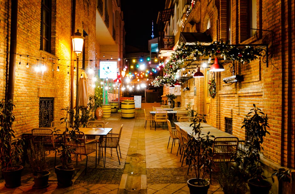 Allée nocturne décorée de guirlandes et terrasses cosy à Tirana