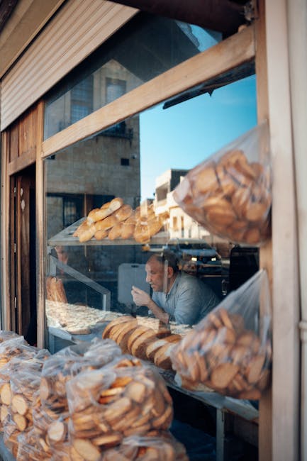 Brood en zakken koekjes in etalage met man achter glas
