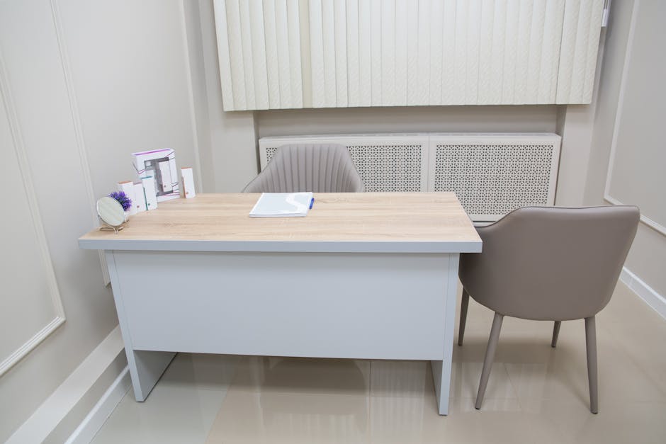 Minimal consultation room with desk, chairs and paperwork in Tirana clinic