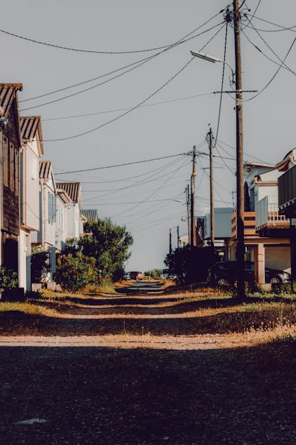 Allée de la périphérie de Tirana bordée de maisons et poteaux électriques