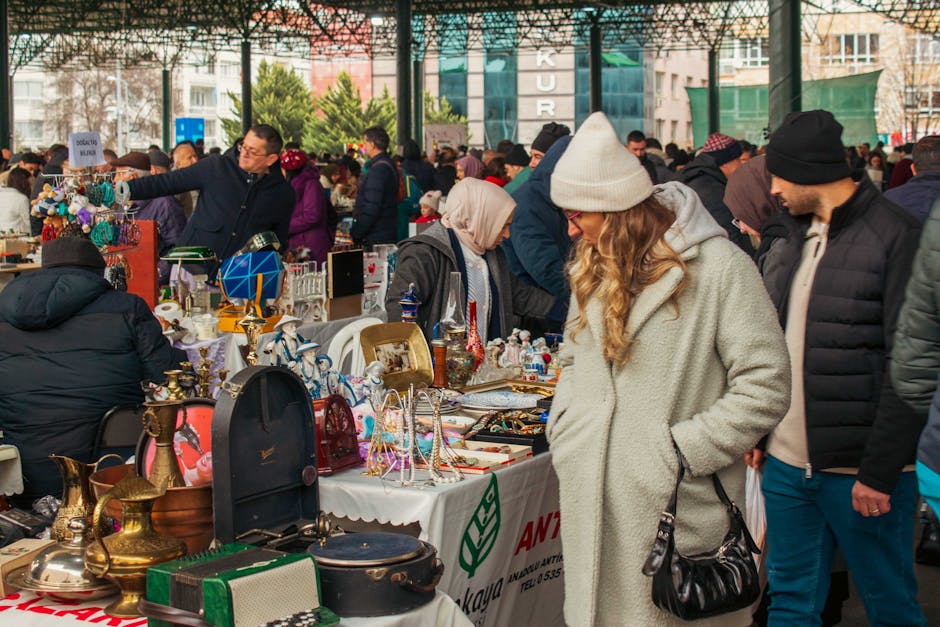 Crowded flea market aisles with shoppers browsing antiques in Tirana