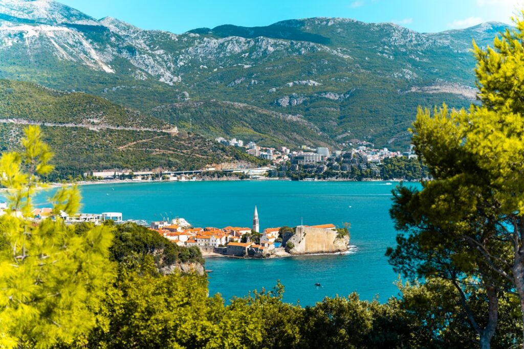 Vue sur Sveti Stefan au Monténégro entouré d'eau turquoise et pins