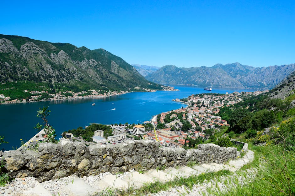 Bucht von Kotor mit Steinmauer, Booten und Kreuzfahrtschiff, Montenegro