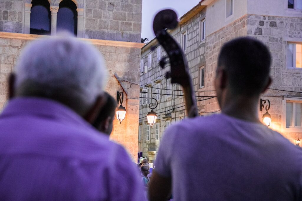 Musiciens jouant en plein air devant pierres anciennes dans une rue du Monténégro