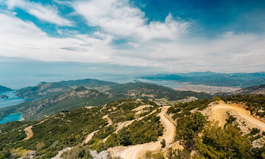 Winding dirt road over Montenegrin hills with coastal view and islands