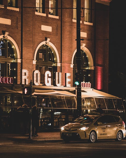 Taxi arrêté devant un restaurant éclairé 'ROGUE' dans les rues de Podgorica