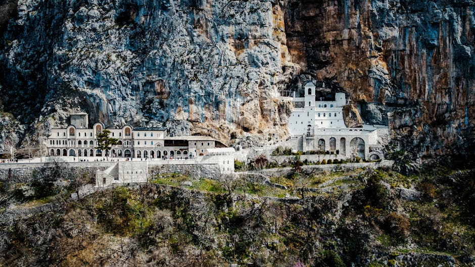 Ostrog Monastery set into a cliff face with pilgrims and visitors