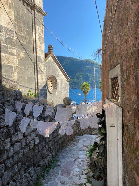 Enge Gasse mit Wäscheleinen vor Kirche und Blick aufs Meer in Montenegro
