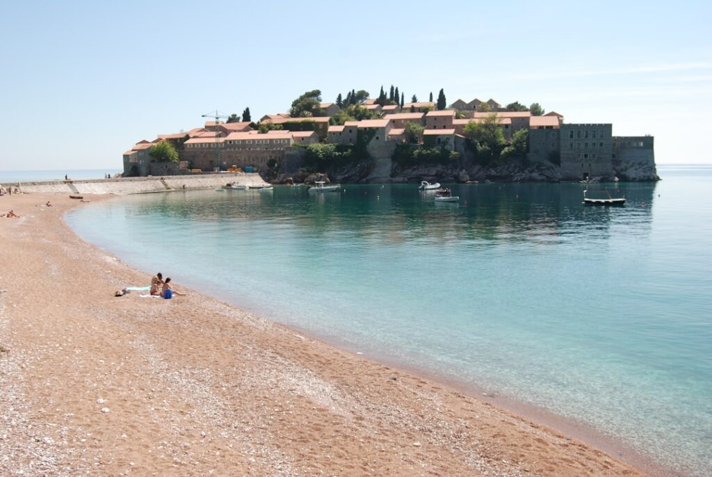 Sveti Stefan Insel vor klarem Wasser und Kiesstrand, Montenegro