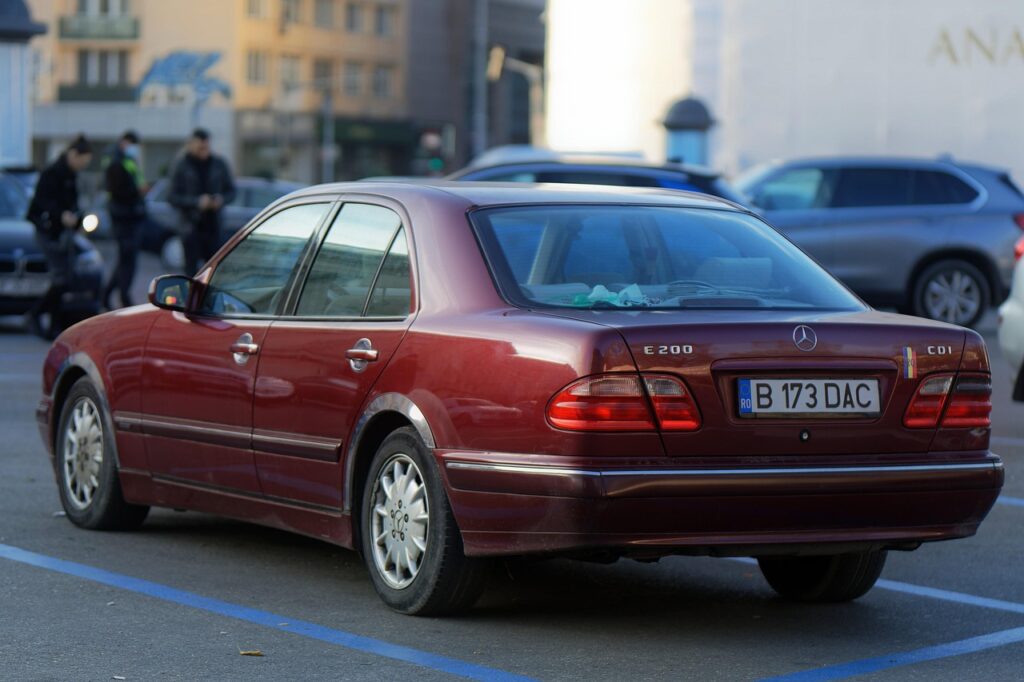 Bordowy Mercedes E200 zaparkowany na miejskim miejscu parkingowym