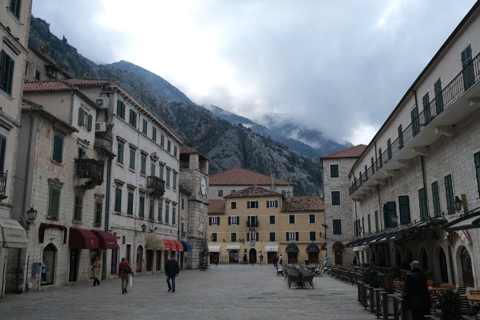 Piazza principale di Kotor con edifici in pietra e montagne del Montenegro