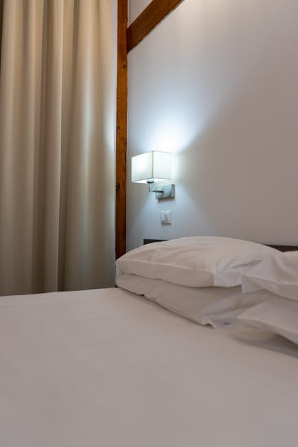 Neatly made bed with lamp and curtains in Montenegro guestroom